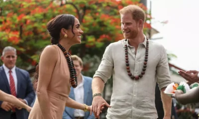 Prince Harry and Meghan Markle flash huge smiles as they land in Nigeria after Royal Family's 'snub' in UK